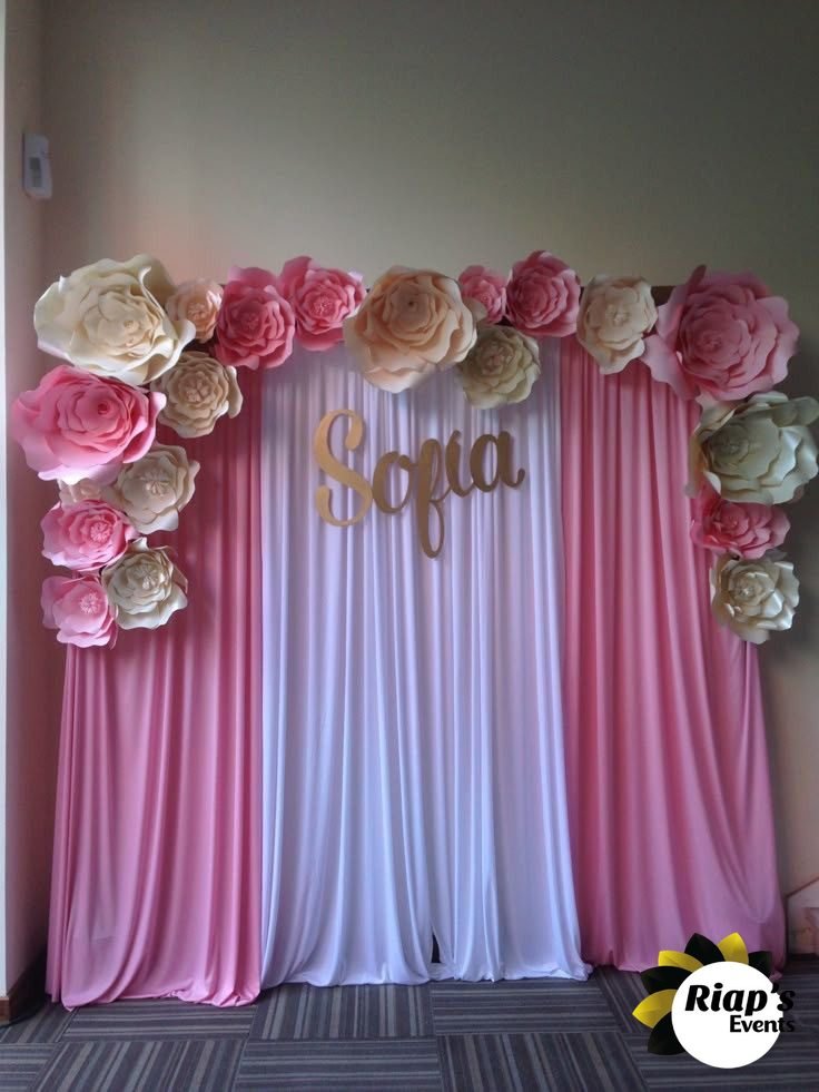 Fond de scène en fleurs de papier roses et voilage